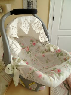 a baby's cradle with white and pink flowers on it