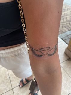 a woman's arm with a tattoo on it and a chain around her ankles