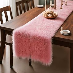 a table with a pink fur runner on it