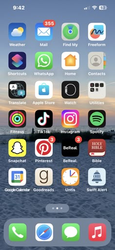 an iphone screen with several different icons on the screen and in the background, there is a sunset
