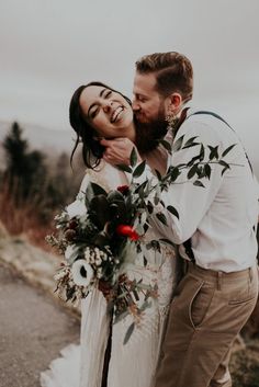 a bride and groom hugging each other on the road