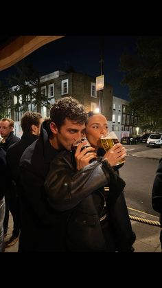 two people drinking beer on the street at night