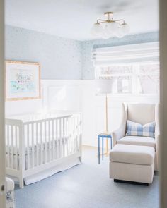 a baby's room with a white crib and blue carpeted flooring