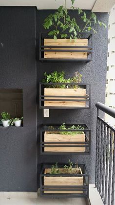 several wooden planters on the side of a building with plants growing out of them