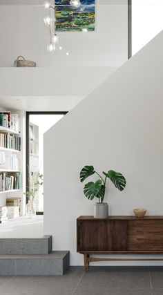 a living room with a book shelf and a potted plant