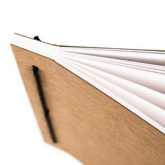 an open book with a pen sticking out of it's cover, on a white background