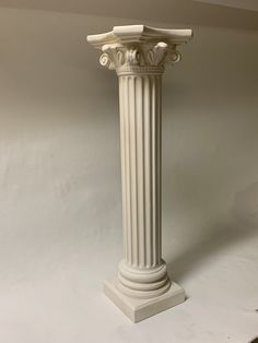 a tall white pedestal with two columns on each side