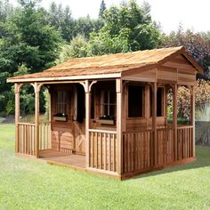 a small wooden shed sitting on top of a lush green field