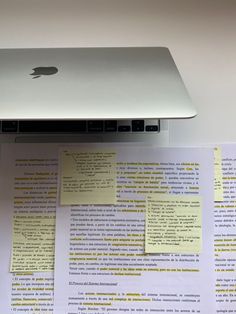 an apple laptop sitting on top of a piece of paper