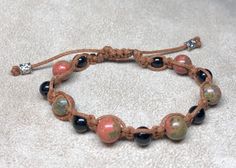 Onyx and unakite beads braided in brown cord. Adjustable 6-9 inches. Pull closed with metal cylinder beads. Casual Brown Braided Bracelets With Round Beads, Casual Braided Bracelets With Natural Stones For Healing, Casual Braided Bracelets With Natural Stones, Casual Adjustable Braided Bracelets With Natural Stones, Casual Brown Macrame Beaded Bracelet, Casual Brown Hand Wrapped Braided Bracelets, Adjustable Brown Braided Bracelets For Healing, Cutesy Outfits, Cutesy Outfit