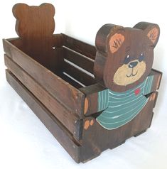 a teddy bear sitting in a wooden crate