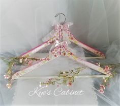 a pink and white dress hanger with flowers on it