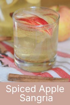 spiced apple sangria in a glass with cinnamon stick on the table next to it