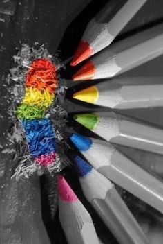 several colored pencils in a black and white photo