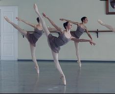 three ballerinas in grey leotards doing ballet moves