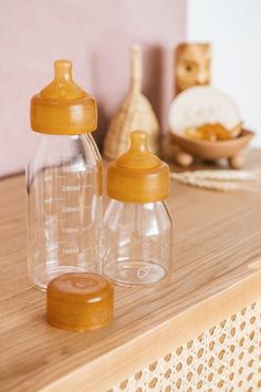 two baby bottles sitting on top of a wooden table