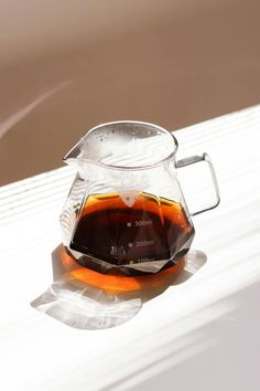 a glass pitcher filled with liquid sitting on top of a table