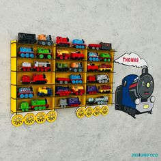 a toy train is on display in front of a wall with thomas the tank engine