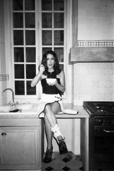 a woman sitting on top of a kitchen counter