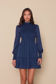 The Lulus Heartful Romance Navy Striped Smocked Long Sleeve Mini Dress has our hearts forever and always! Airy woven chiffon (with textured dots, metallic lurex, and tonal stripes throughout) shapes a ruffle-trimmed mock neckline, a smocked bodice, and long sheer sleeves with ruffles at the shoulders and smocking at the cuffs. Flowy mini skirt has a tiered hem. Back keyhole secures with a button closure. Fit: This garment fits true to size. Length: Mid-thigh. Size medium measures 35" from should Short Winter Dresses With Boots, Short Winter Dresses, Winter Dresses With Boots, Dresses With Boots, Bach Bash, Flowy Mini Skirt, Forever And Always, Mock Neckline, Long Sleeve Mini