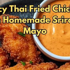 fried chicken in homemade srirac mayo sauce on a plate with the words spicy thai fried chicken