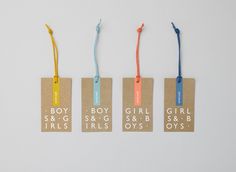 four small tags with the words boy, girl and girls on them hanging from strings