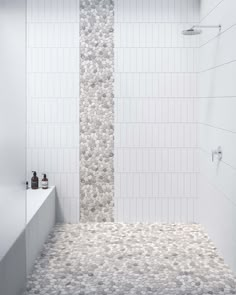 a white tiled bathroom with two shower heads