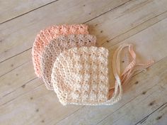 three crocheted bags sitting on top of a wooden floor