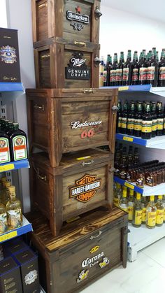 three wooden crates stacked on top of each other in a store filled with beer bottles