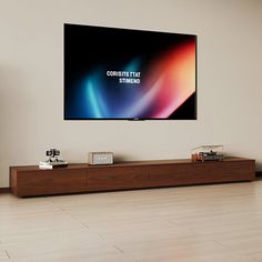 a flat screen tv mounted on the wall above a wooden entertainment unit in a living room