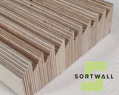 several pieces of wood are stacked on top of each other with the word sortwall above them