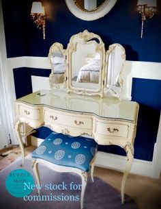 a bedroom with blue walls and furniture in the room, including a vanity table and stool