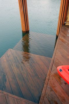 a red surfboard sitting on top of a wooden dock