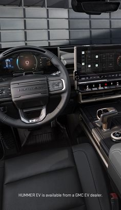 the interior of a car with an electronic display and steering wheel, dash board, and dashboard controls