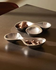 three spoons with nuts in them sitting on a table