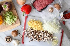 an assortment of vegetables and meat on a cutting board