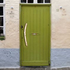 a green door with a stick sticking out of it