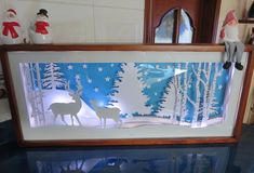 an image of a christmas scene with deer and snowflakes in the window frame