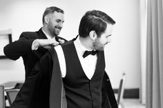 two men in tuxedos are getting ready to tie their ties