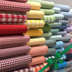 many different colored sheets are stacked on top of each other with ribbons in front of them