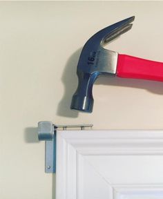 a hammer hitting a door with a red handle