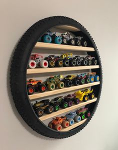 a wall mounted toy car display in the shape of a circle with wheels on it