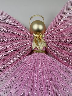 a pink and gold dress with a golden bell on it