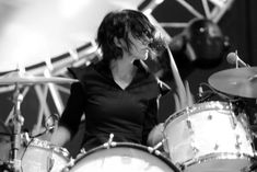 a woman is playing drums on stage