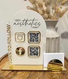 there is a white vase with some gold decorations on it and a qr code