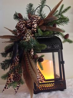 a lantern decorated with pine cones and leopard print ribbon