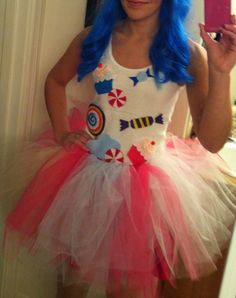 a girl with blue hair wearing a dress and holding a cell phone in her hand