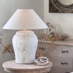 a white lamp sitting on top of a wooden table