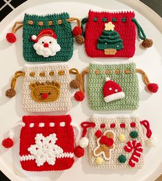 four crocheted christmas purses on a white plate with santa's helper