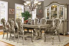 a dining room table with chairs and a chandelier in the middle of it